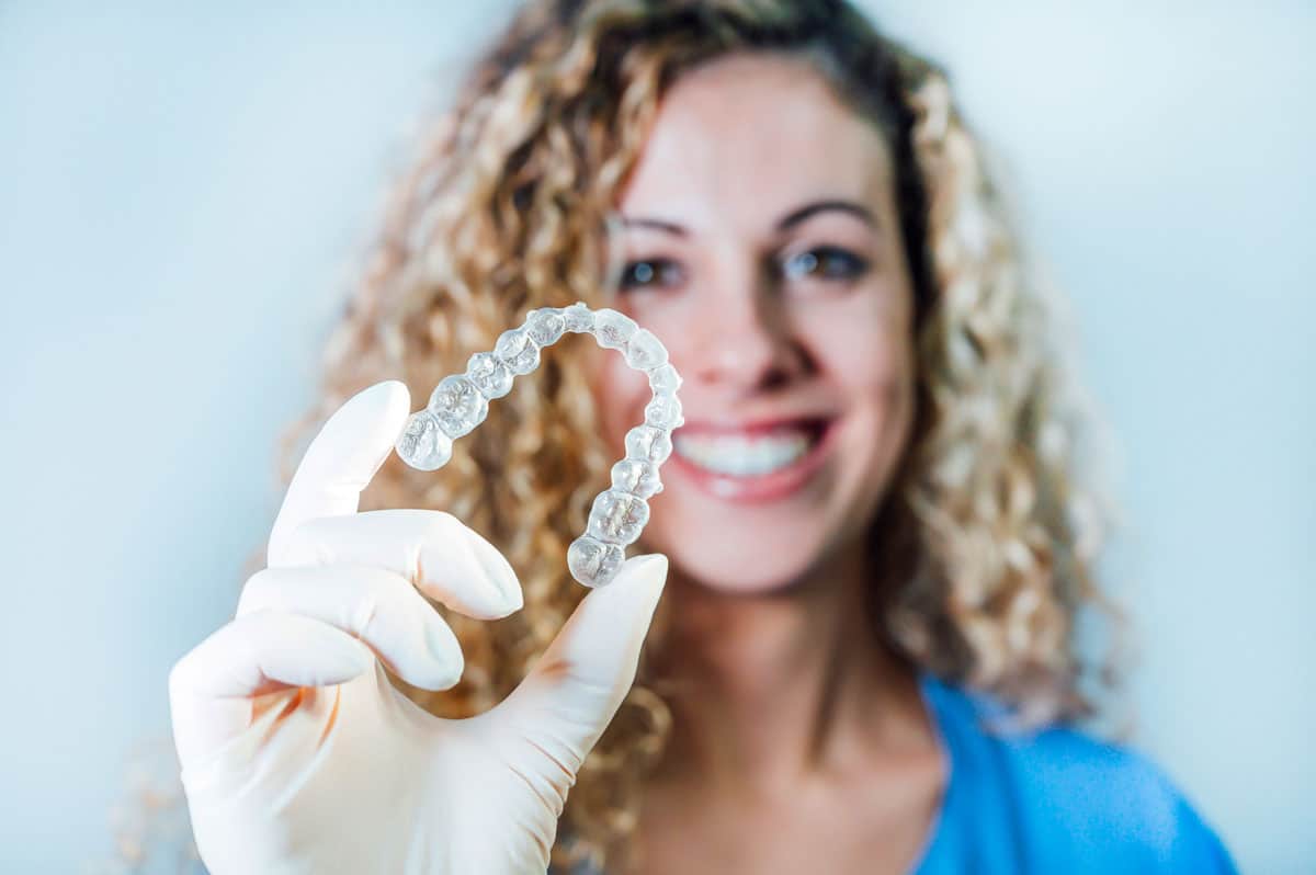 Female dentist holding invisalign dental aligners