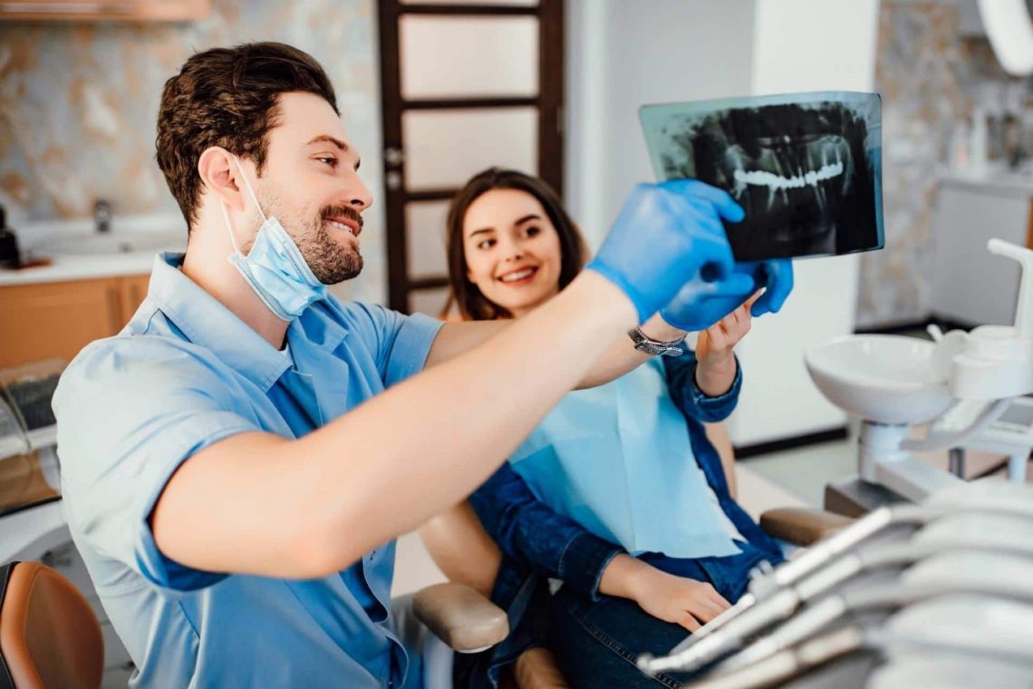 Male dentist showing teeth x ray